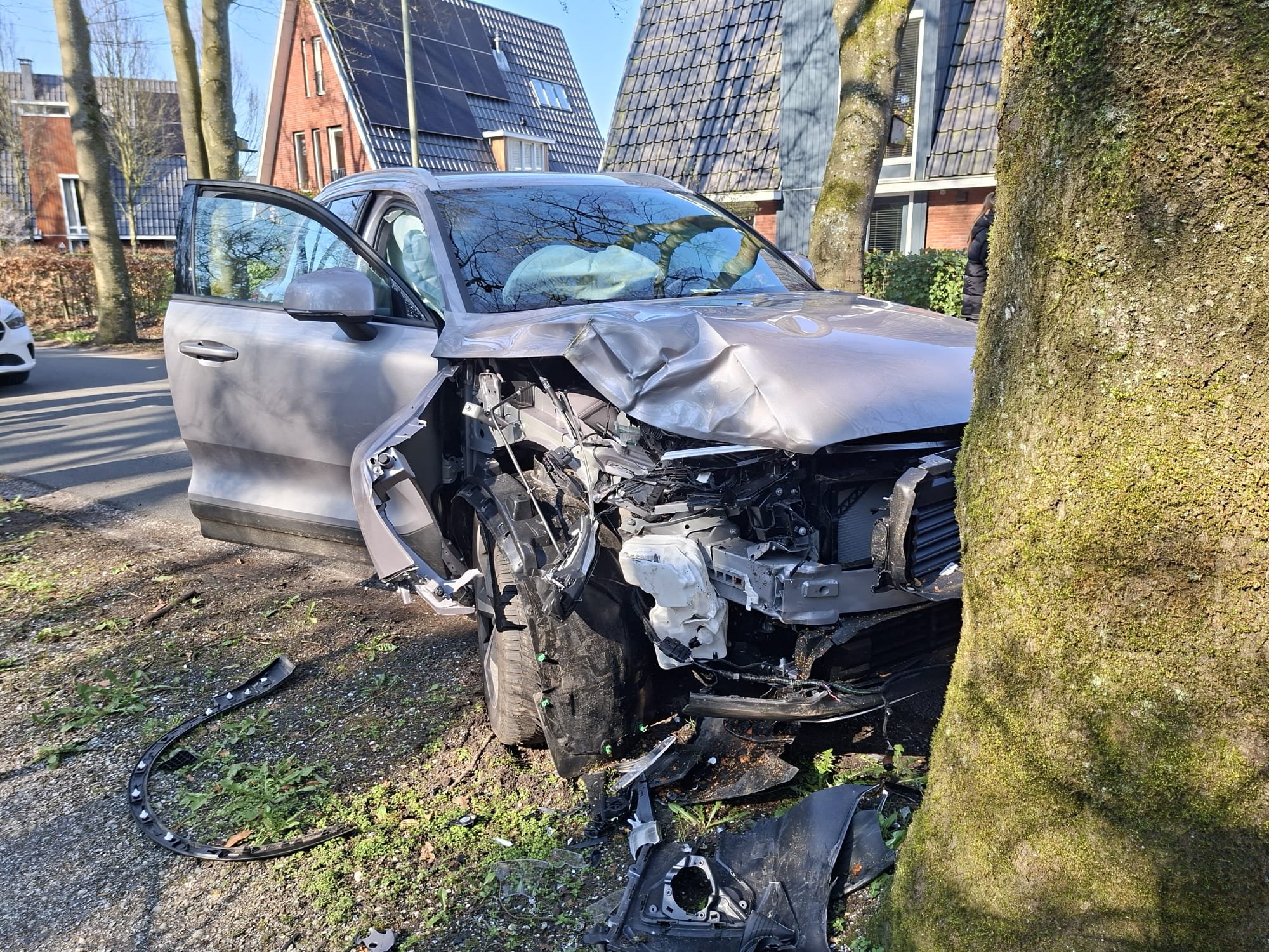 Foto: Auto zwaar beschadigd na botsing tegen boom in Nunspeet