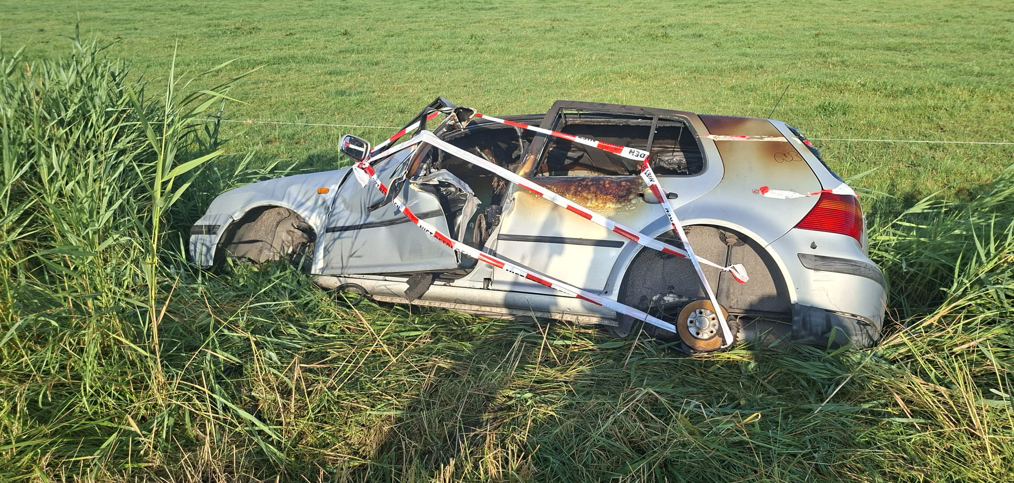 Foto: Wekenlang staat deze auto langs de weg, nu is het een brandwrak