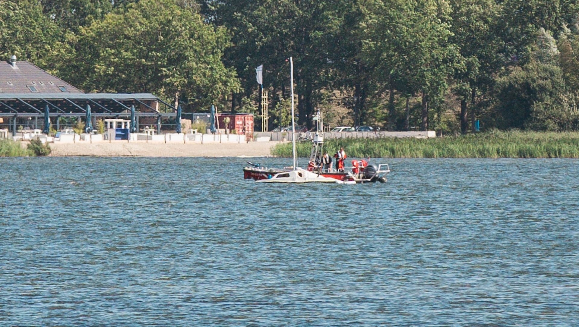 Foto: Boot zinkt op Wolderwijd, omstander helpt opvarende uit water