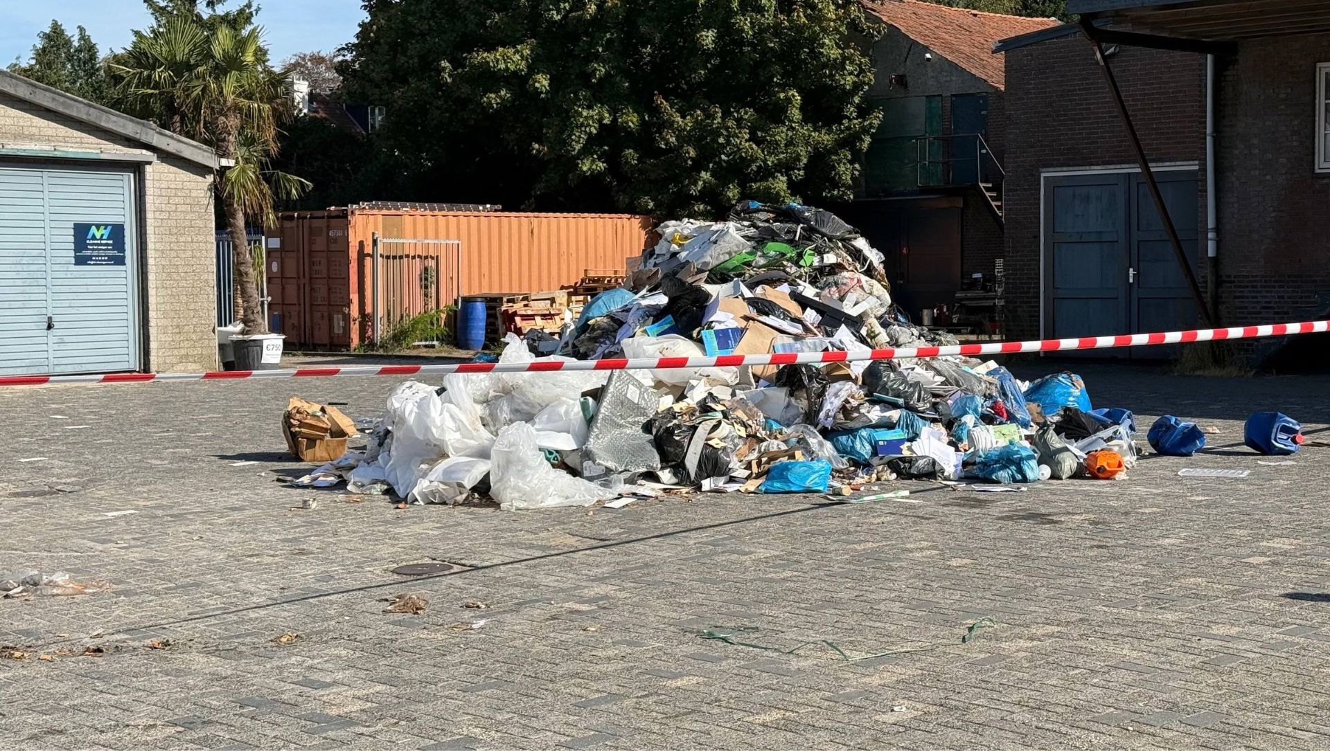 Foto: Vuilniswagen stort smeulende lading bij tankstation in Nunspeet